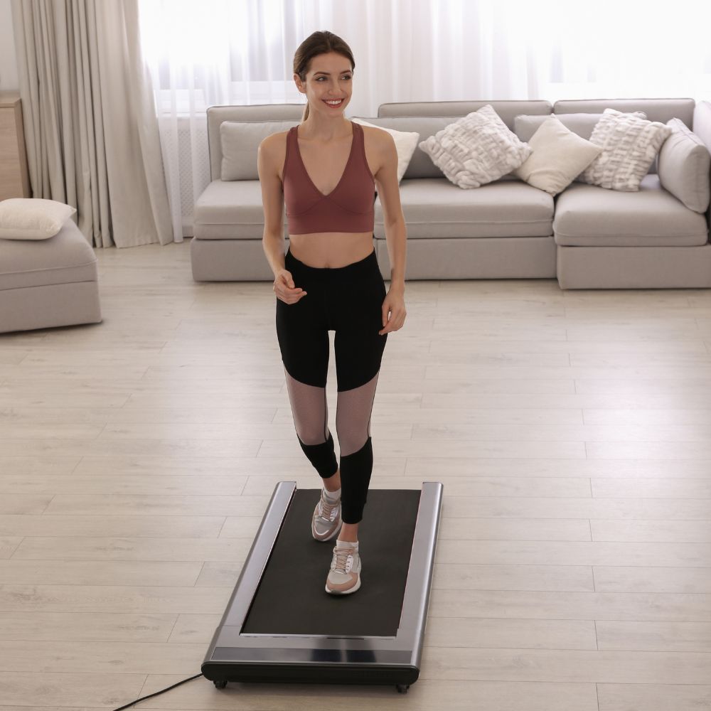 Woman using a treadmill in a living room setting